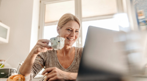 Lady drinking tea and browsing laptop